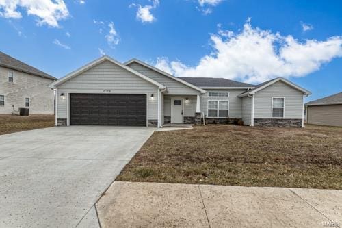 view of front of home featuring a garage, central AC, and a front lawn