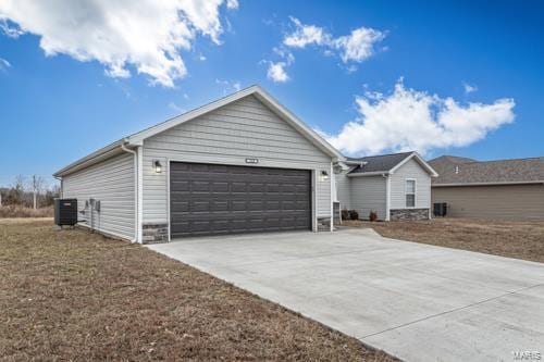 ranch-style house featuring a garage and central AC