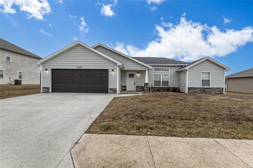 view of front of house featuring a garage, a front lawn, and central air condition unit