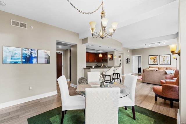 dining area with hardwood / wood-style flooring and a chandelier