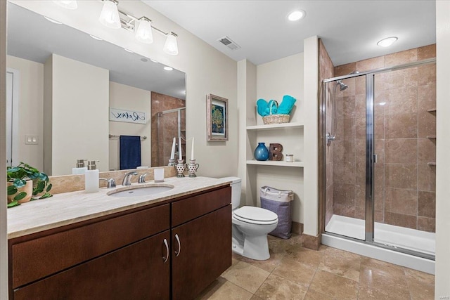 bathroom featuring vanity, toilet, and a shower with shower door