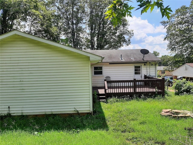 back of house featuring a deck and a lawn