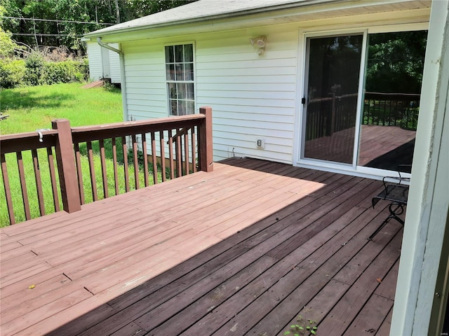 wooden deck featuring a lawn