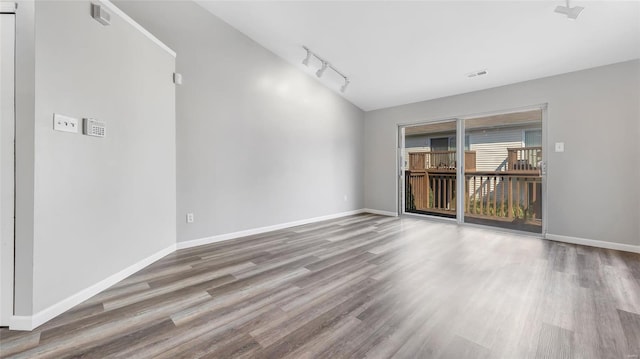 spare room with hardwood / wood-style flooring and track lighting