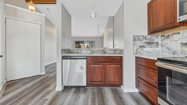 kitchen featuring stainless steel appliances, sink, tasteful backsplash, and dark wood-type flooring