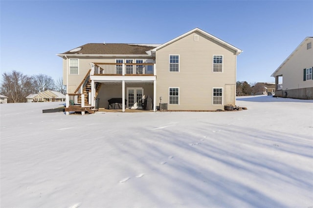 snow covered property featuring french doors and a deck