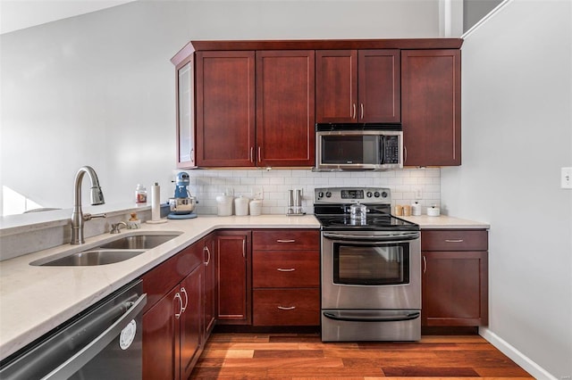 kitchen featuring sink, stainless steel appliances, dark hardwood / wood-style flooring, and tasteful backsplash