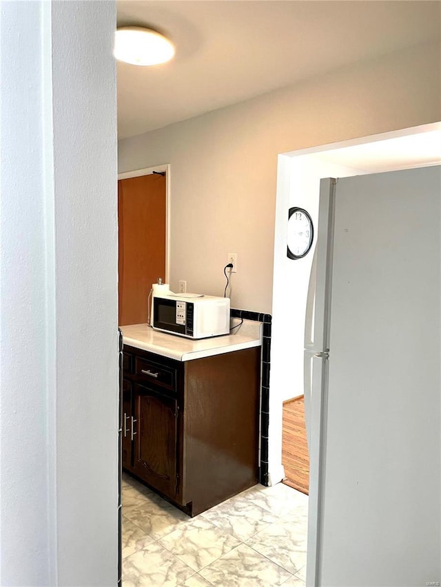 kitchen featuring dark brown cabinets and white refrigerator