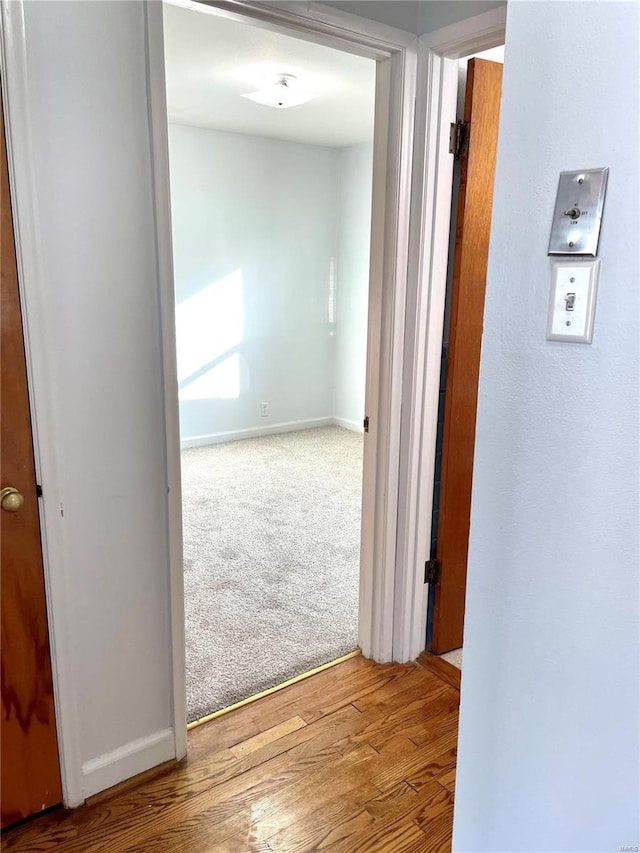 corridor with hardwood / wood-style flooring