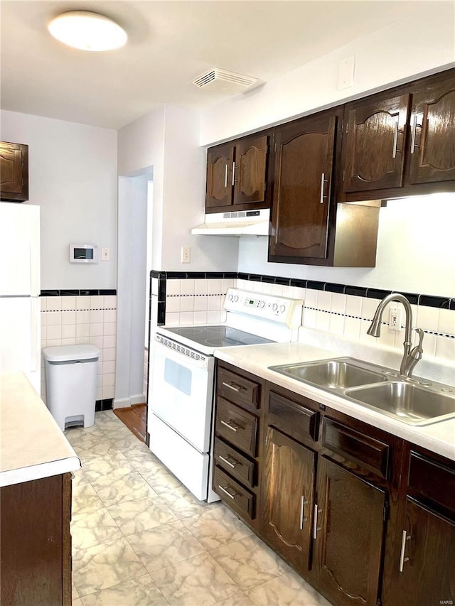 kitchen featuring sink, white appliances, dark brown cabinetry, and tile walls