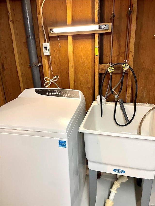 laundry area featuring sink, washer / dryer, and wooden walls