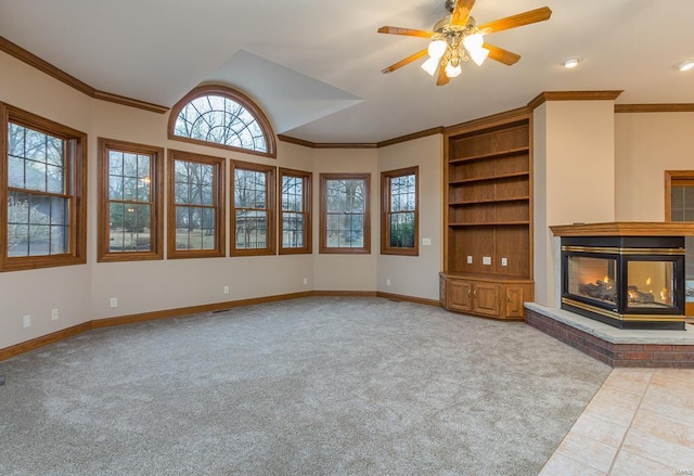 unfurnished living room with ceiling fan, light colored carpet, crown molding, and a fireplace