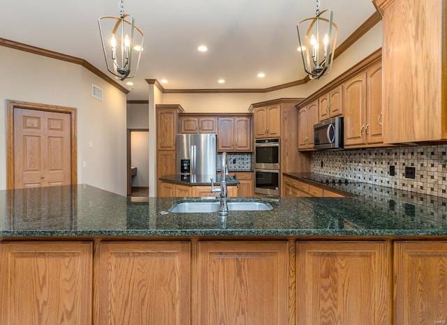 kitchen with decorative backsplash, appliances with stainless steel finishes, pendant lighting, and a chandelier