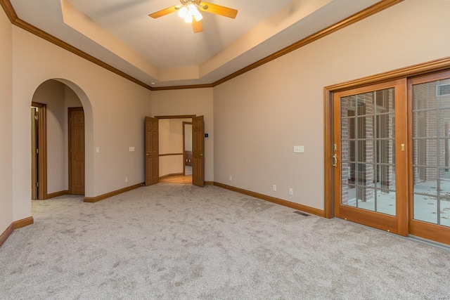 interior space with ceiling fan, crown molding, light carpet, and a raised ceiling