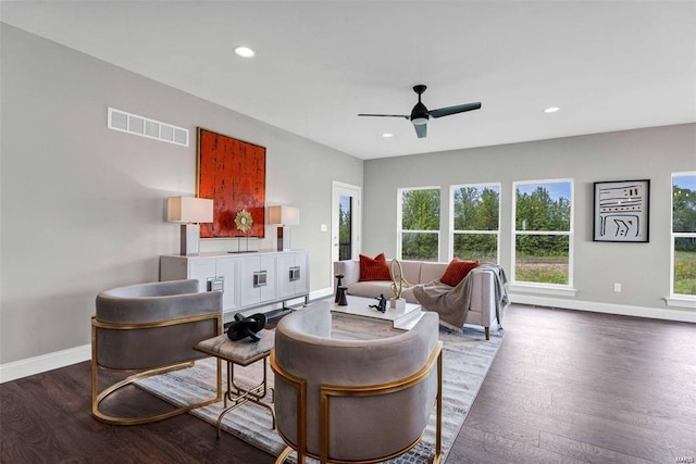 living room with dark wood-type flooring and ceiling fan