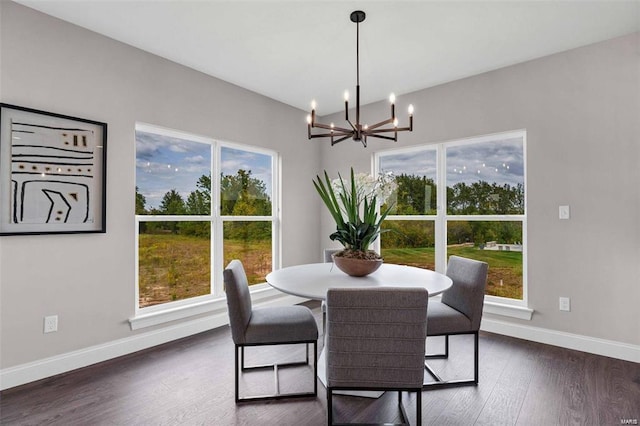 dining area with a healthy amount of sunlight, dark hardwood / wood-style flooring, and a notable chandelier