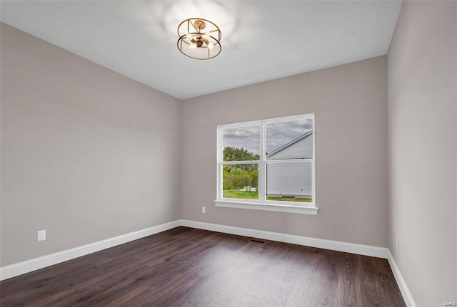 spare room featuring dark wood-type flooring