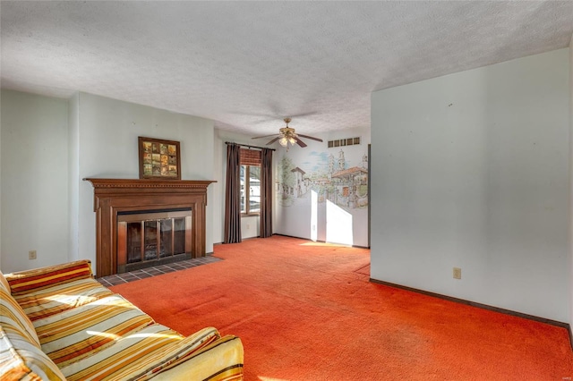 unfurnished living room with visible vents, a fireplace with flush hearth, ceiling fan, carpet, and a textured ceiling