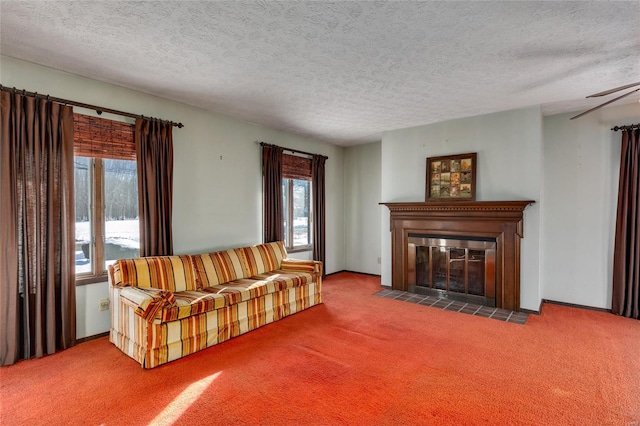 living room featuring a fireplace with flush hearth, carpet flooring, a textured ceiling, and baseboards