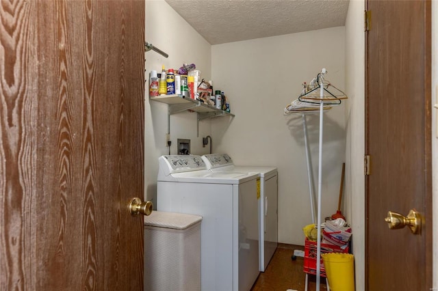 clothes washing area with washer and dryer, laundry area, and a textured ceiling