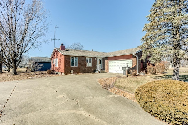 ranch-style home with a garage, a chimney, concrete driveway, and brick siding