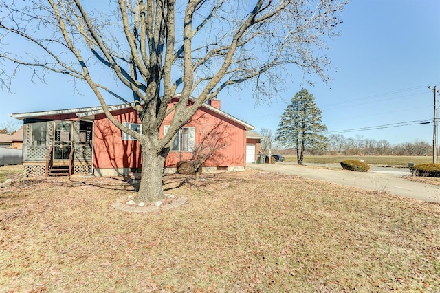 exterior space with concrete driveway, crawl space, and a chimney