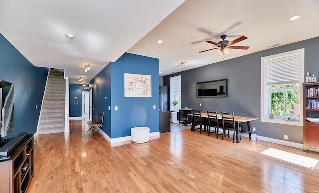 living room featuring light hardwood / wood-style floors and ceiling fan