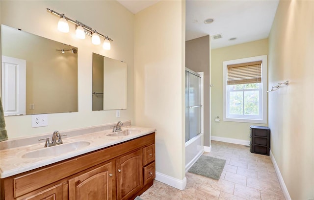 bathroom with tile patterned floors, vanity, and enclosed tub / shower combo