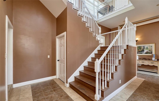 staircase featuring a high ceiling and tile patterned flooring