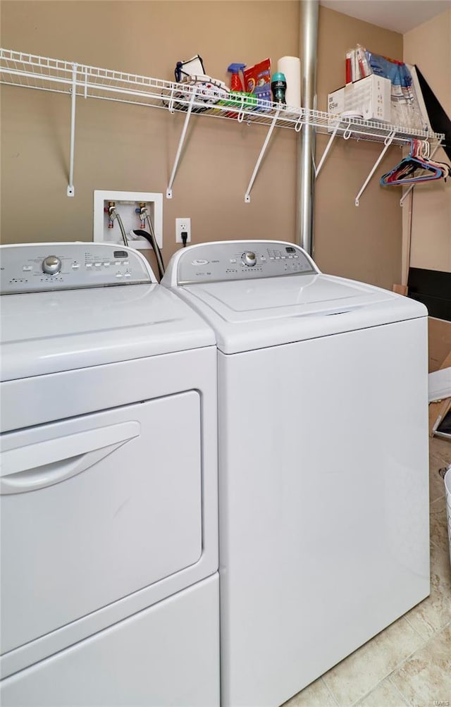 clothes washing area with light tile patterned floors and separate washer and dryer