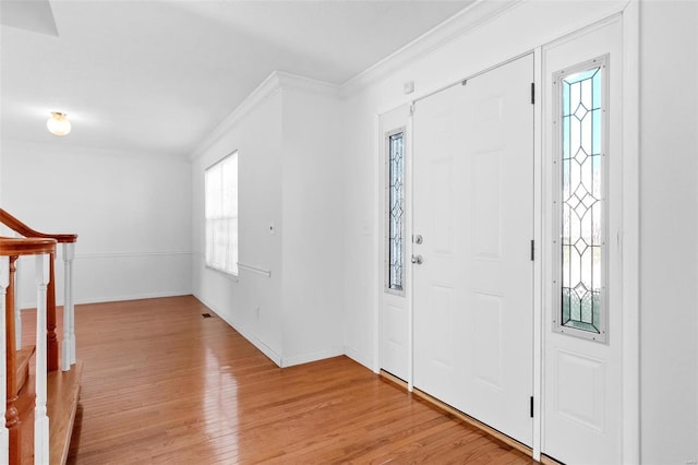 entryway featuring light wood-type flooring and crown molding