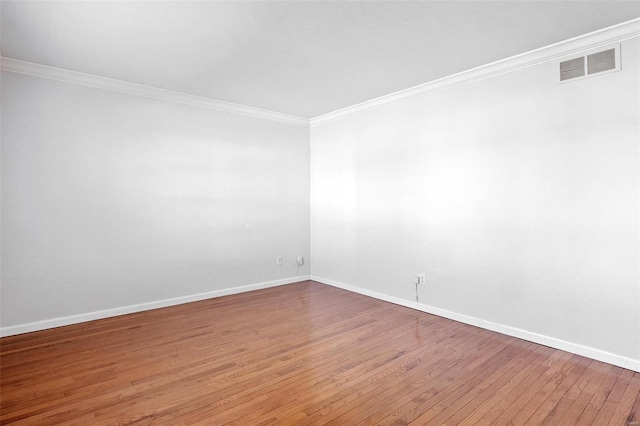 empty room featuring crown molding and hardwood / wood-style flooring