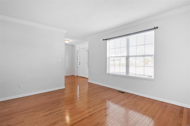 empty room with hardwood / wood-style flooring and ornamental molding