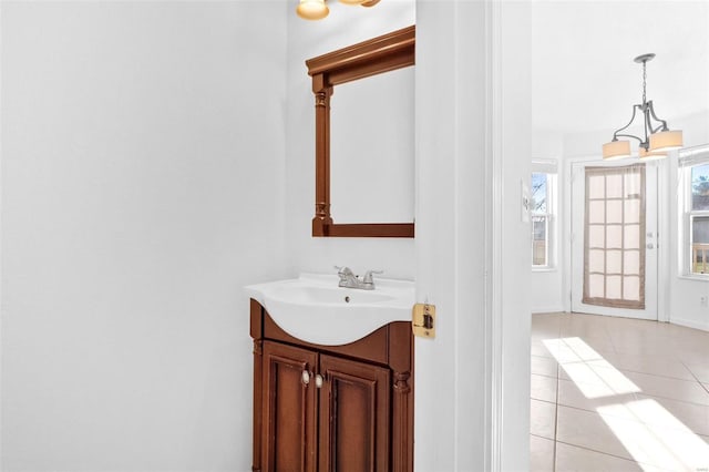 bathroom featuring tile patterned floors, vanity, and an inviting chandelier