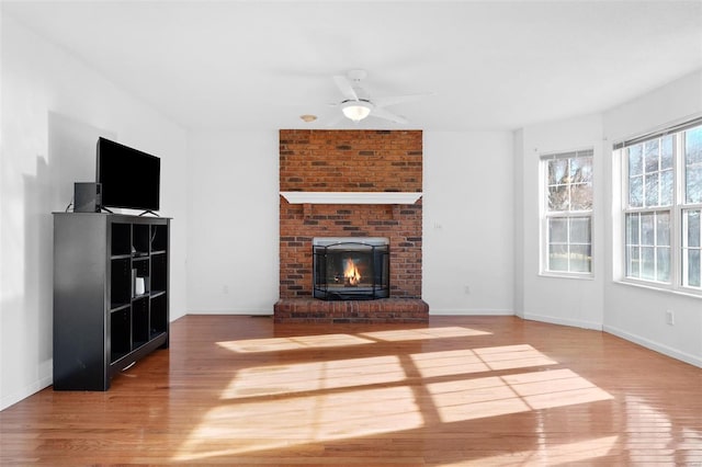 unfurnished living room featuring ceiling fan, a fireplace, and hardwood / wood-style floors