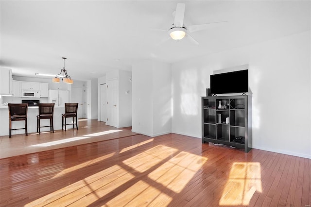 unfurnished living room with light wood-type flooring and ceiling fan