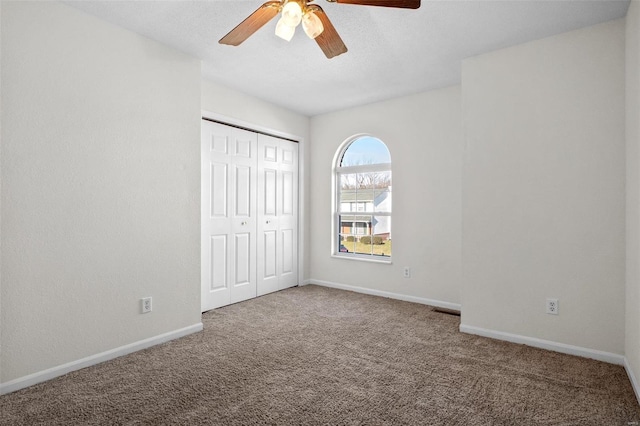 unfurnished bedroom with a closet, carpet, and ceiling fan