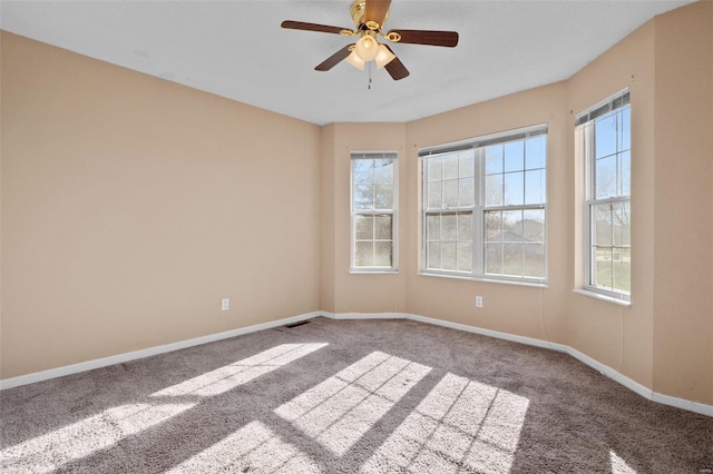 unfurnished room with ceiling fan and carpet