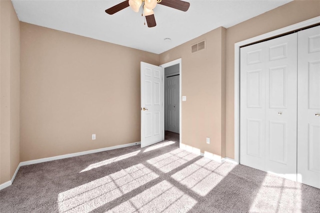 unfurnished bedroom featuring ceiling fan, a closet, and light carpet