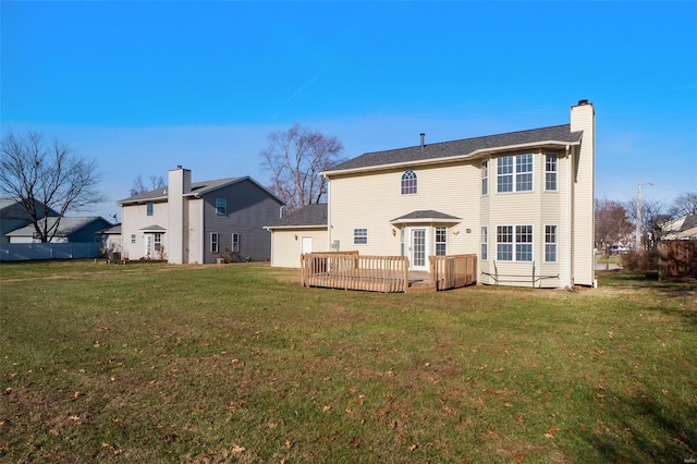 rear view of house with a wooden deck and a yard