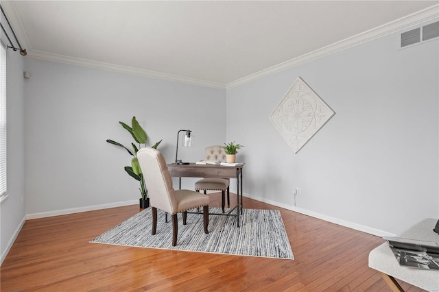 office area featuring crown molding, visible vents, baseboards, and wood finished floors