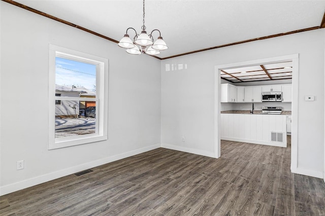 unfurnished dining area featuring dark wood-type flooring, ornamental molding, and a notable chandelier