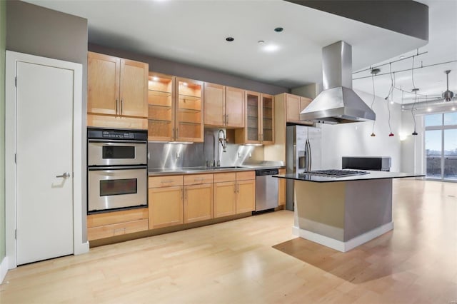 kitchen featuring sink, stainless steel appliances, a center island, island range hood, and light hardwood / wood-style floors