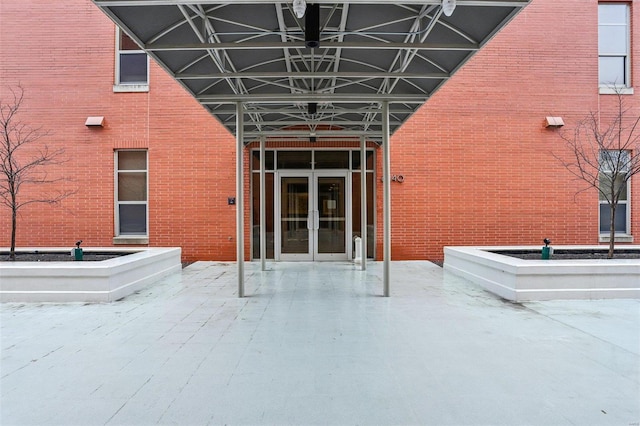 view of exterior entry with french doors and brick siding