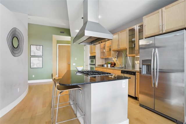 kitchen with a center island, island exhaust hood, stainless steel appliances, light wood-style flooring, and a sink