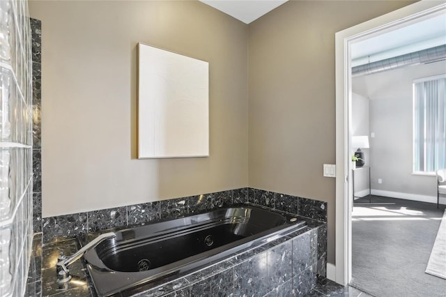 bathroom with baseboards and a whirlpool tub