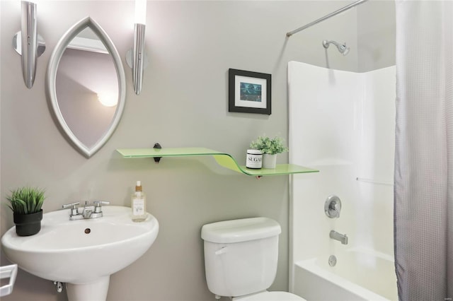 full bath featuring toilet, shower / bathtub combination with curtain, and a sink