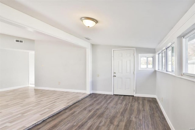 spare room featuring vaulted ceiling and hardwood / wood-style flooring