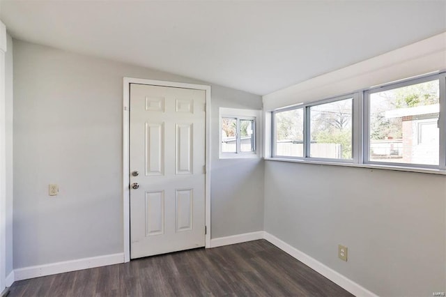 empty room featuring lofted ceiling and dark hardwood / wood-style floors