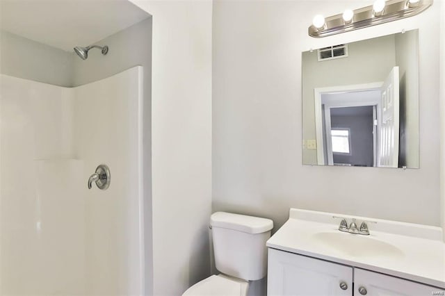 bathroom featuring a shower, vanity, and toilet